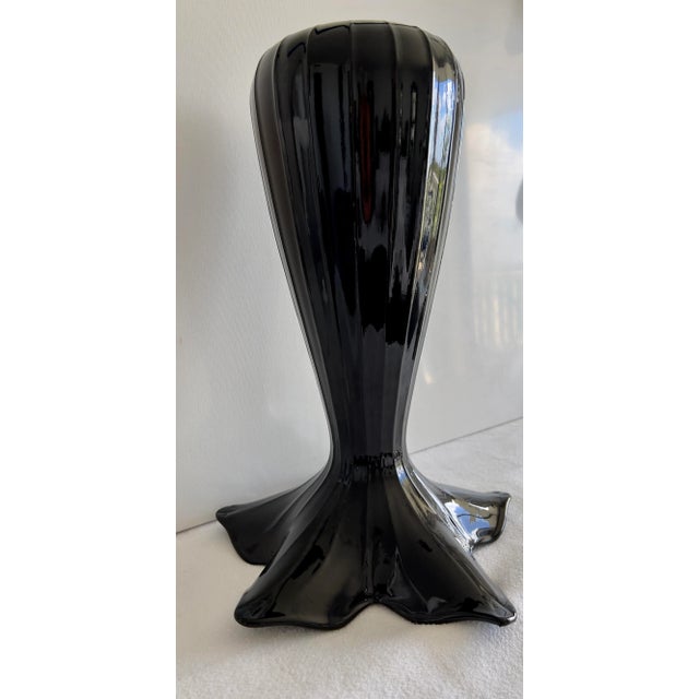 This is an exquisite and unusual tall black glass vase with a flared top. It will fit perfectly into mid-century or art...
