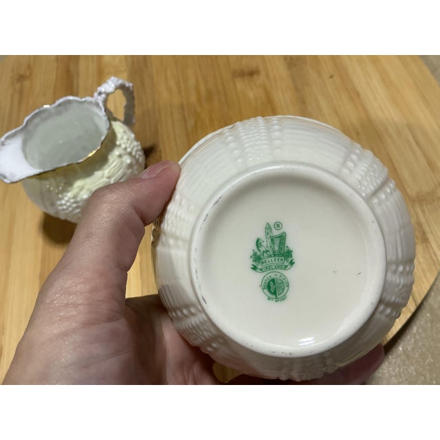 A charming vintage two-piece cream pitcher and open sugar bowl set crafted by Belleek Pottery in Ireland. Featuring the...