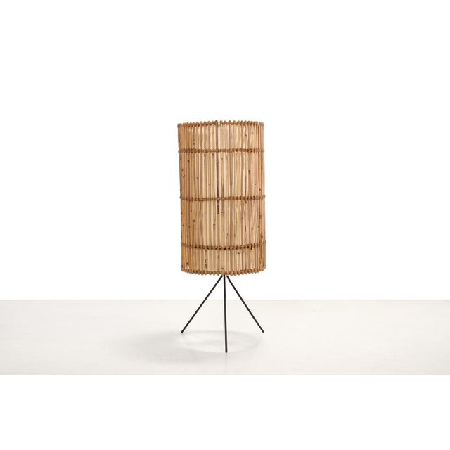 Beautiful floor lamp from France in the style of Louis Sognot. Made of bamboo and rattan with a metal tripod base and...