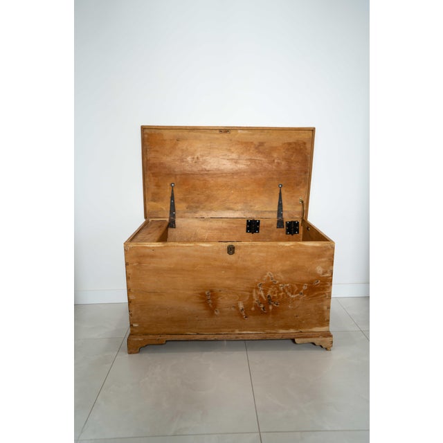 A beautifully worn pine storage chest with original iron hardware and a softly aged surface that tells its history at a...