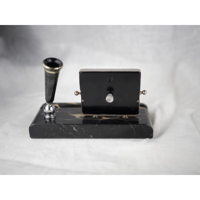 Nickel-plated perpetual calendar, day and month in german. Articulated black and gold flared shape pencil case. Impressive...