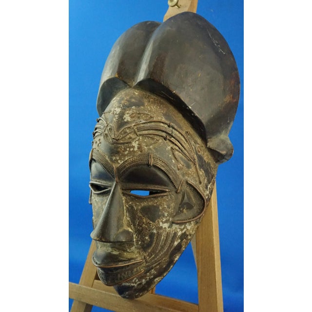 Item description: African tribal mask made of wood, presumably Wengé wood, entirely hand-carved with numerous copper...
