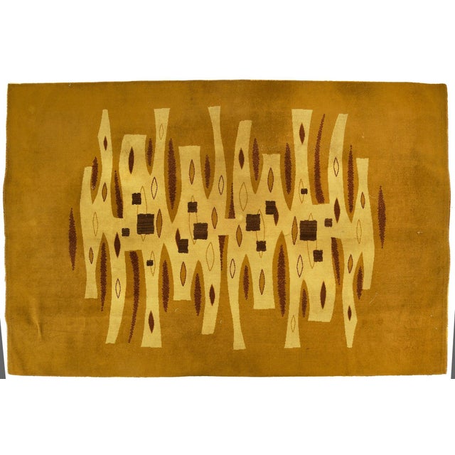 Hand-knotted in wool, this 6x10 vintage French rug, circa 1970, is a striking example of mid-century modern design...