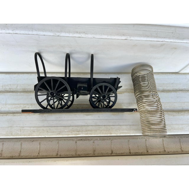 Mid century model of a Western Chuck Wagon with a metal slinky inside. The "Chuck Wagon" desk decoration is a charming and...