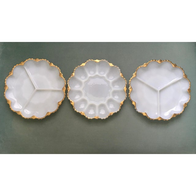 A beautiful trio of milk glass gilt edged serving plates with two divided into sections of three and one with twelve...
