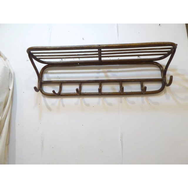 This bentwood set of 7 coat hooks with shelf for hats has layers of old paint.