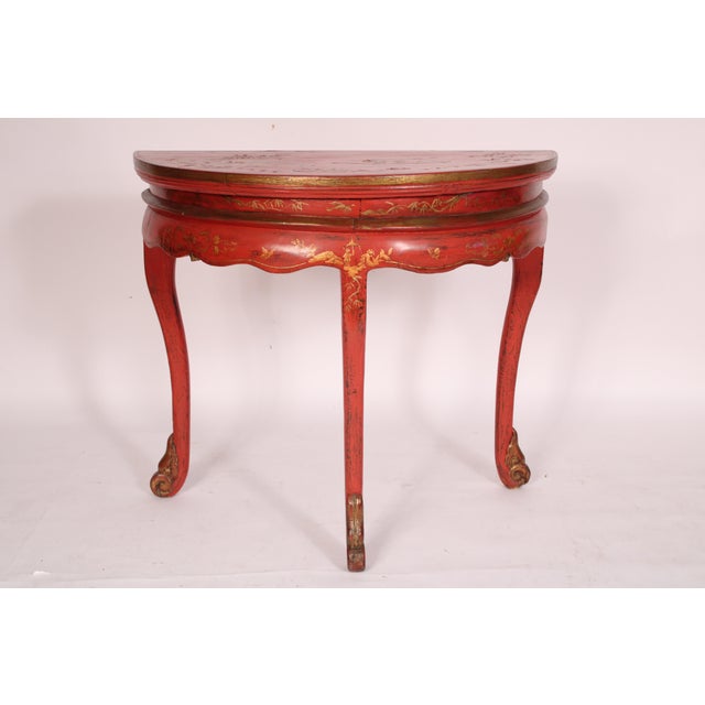 Chinese red chinoiserie decorated demi lune console table, circa 1900. With a demi lune top with raised gilt chinoiserie...