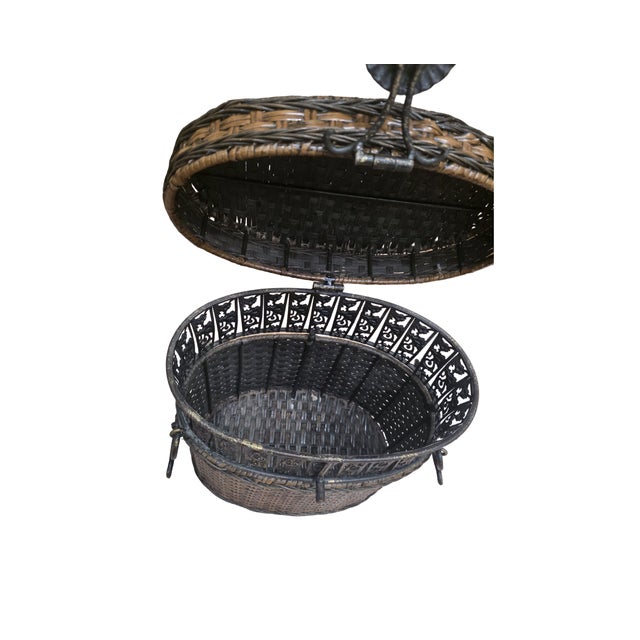 Beautiful vintage woven rattan storage basket featuring an ornate pierced metal frame, decorative floral clasp, and side...