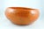 This large, solid bowl was formed from a strong clay with a bright orange glaze. In the fire, it deformed slightly and is...