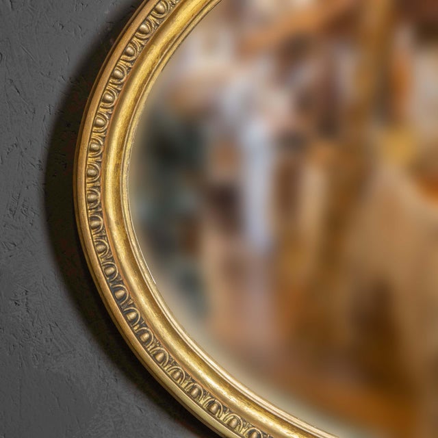 A good Edwardian oval mirror in the manner of Robert Adam. The crest to the top is of a large basket of fruits with...