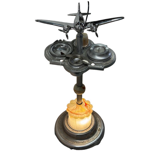 Art Deco chrome airplane and astray stand featuring a light-up art glass base. This dual-purpose accent lamp and ashtray...