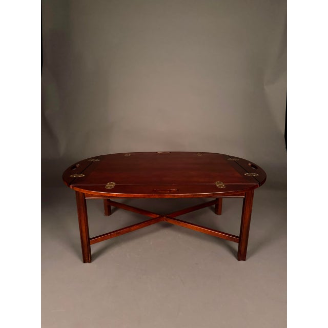 A handsome English-style mahogany Butler’s drop-leaf tray coffee table, crafted with traditional design details and...