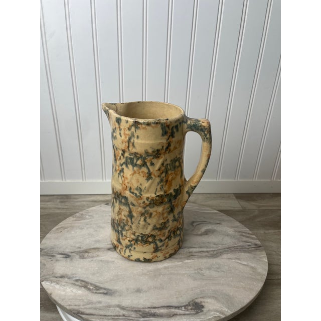 This heavy-weight, authentic American spongeware pitcher is a masterclass in late 19th-century utilitarian pottery....