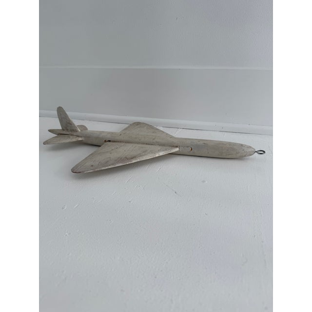 Vintage hand-carved wooden jet plane. Whitewashed finish with natural wear and grain showing through, mounted with a...