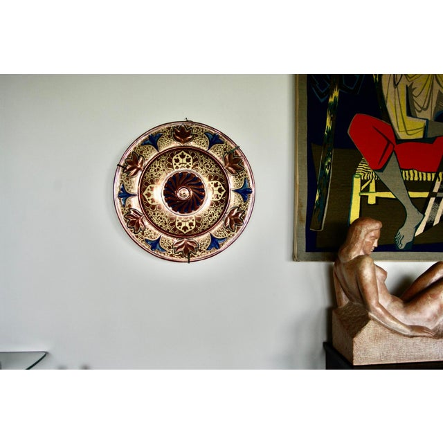 Central rounded decoration adorned with molded gadroons, surrounded by a frieze of stylized flowers and leaves on a dotted...