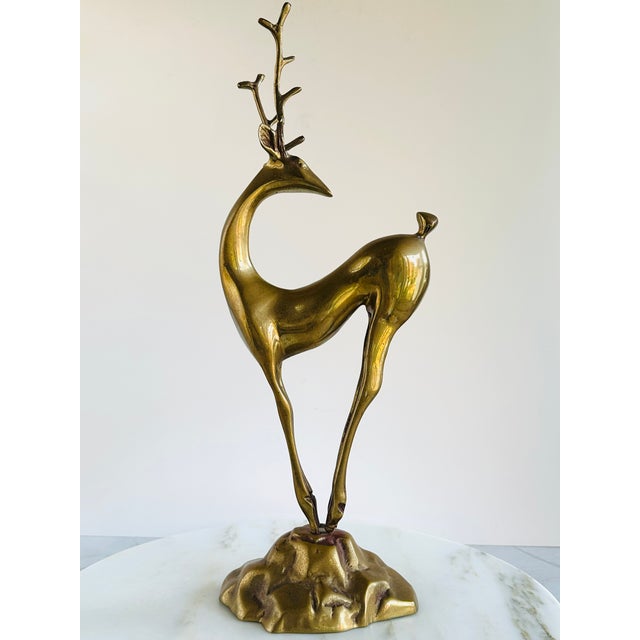 This tall, stylized deer figure is mounted to a base that resembles a golden mountain peak & is appealing from all angles.