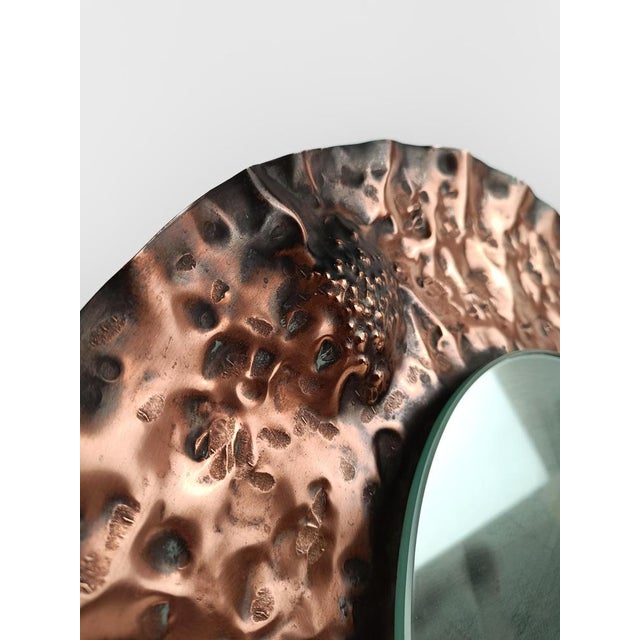 A mid-century mirror with an unusual and sinuous shape, the circular shape becomes three-dimensional, rising and falling,...