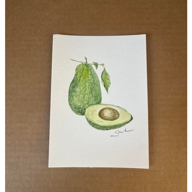 Original artwork, one of a kind. Signed by the artist. A charming botanical watercolor study of an avocado, shown whole...