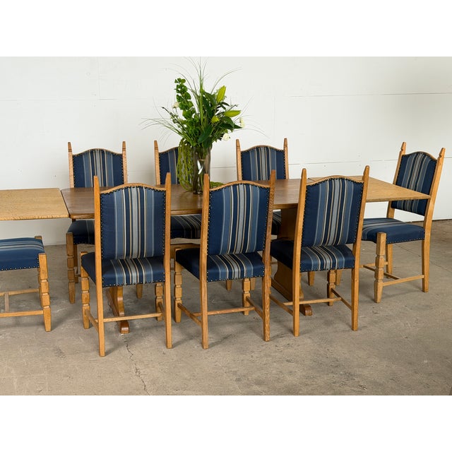This oak trestle dining table is executed in the manner of Henning Kjærnulf, likely produced in Denmark during the 1960s....