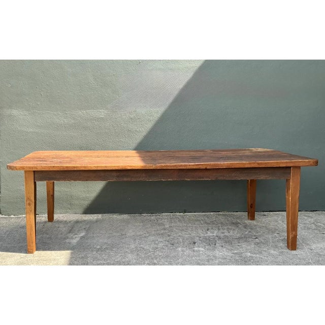This exceptional vintage rustic farm table is masterfully crafted from impressively wide planks of solid wood, showcasing...