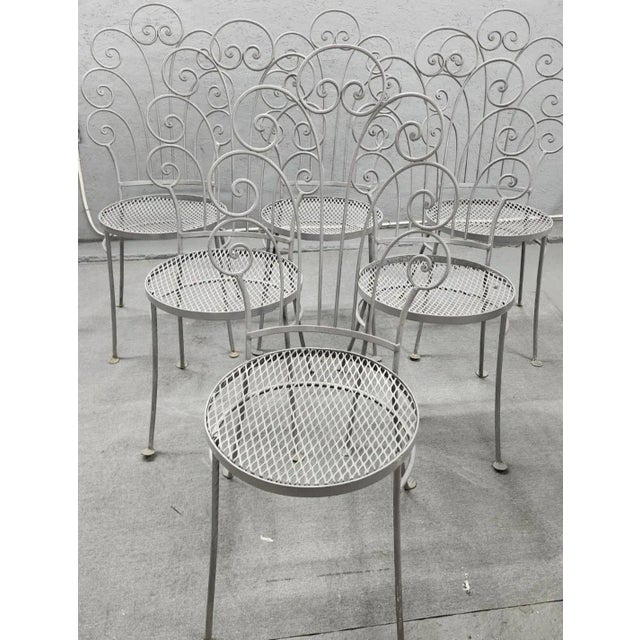 This beautifully designed and well thought out vintage eight-piece wrought iron outdoor dining set is a stunning addition...