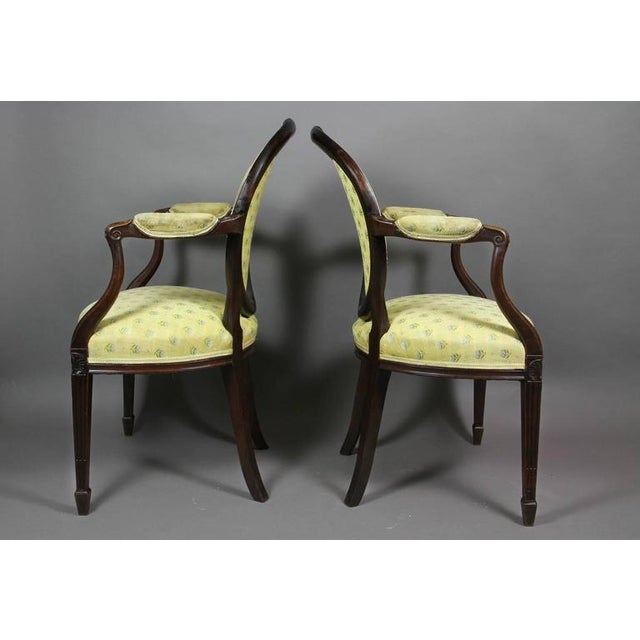 Oval upholstered back with oval carved paterae and bellflower crestrail , carved downswept arms and serpentine upholstered...