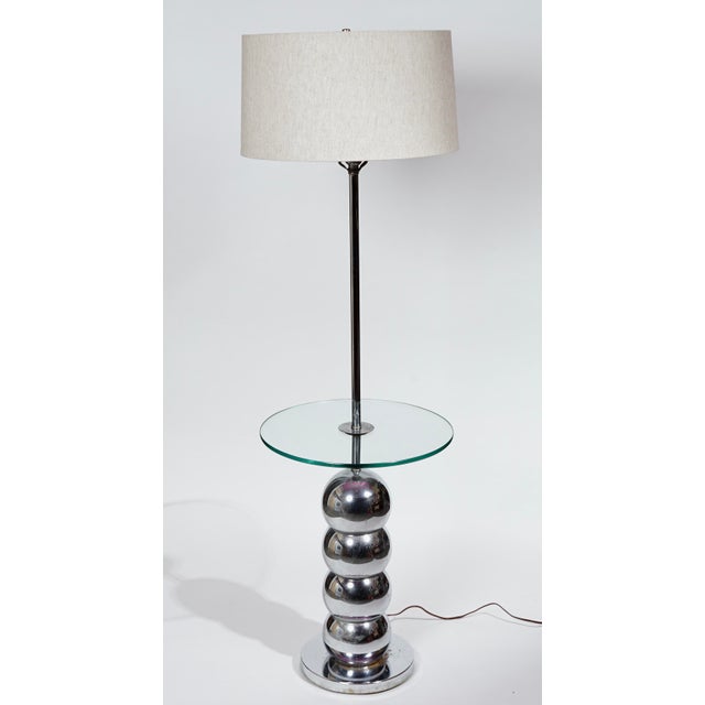 1960s Mod floor lamp with the practical addition of a circular glass table affixed midway up the pole Base is comprised of...