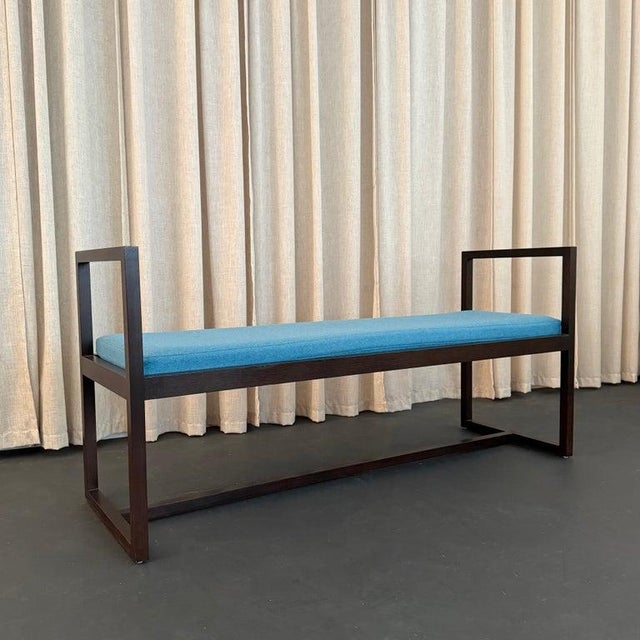 This Mid-century modern bench features a clean, geometric, lacquered mahogany frame with high handled sides that nicely...