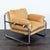 Add a cozy touch to your space with this West Elm lounge chair. It features a soft tan cushion and a sleek chrome frame....