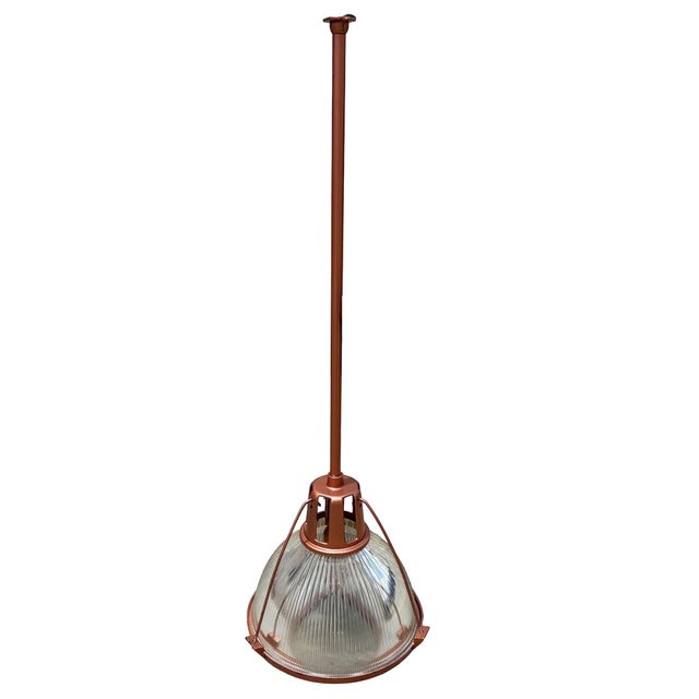This industrial yet elegant hanging light from 1940 features a Holophane glass shade. The pendant is casted in...