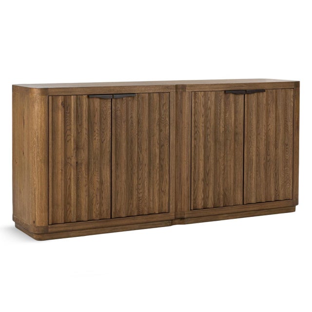 Crafted with an oak veneer, this sideboard has softly fluted door fronts, gently rounded corners, and sleek dark metal...