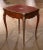 Featuring intricate marquetry and finely detailed gilt bronze mounts, this antique Louis XV style side table reflects the...