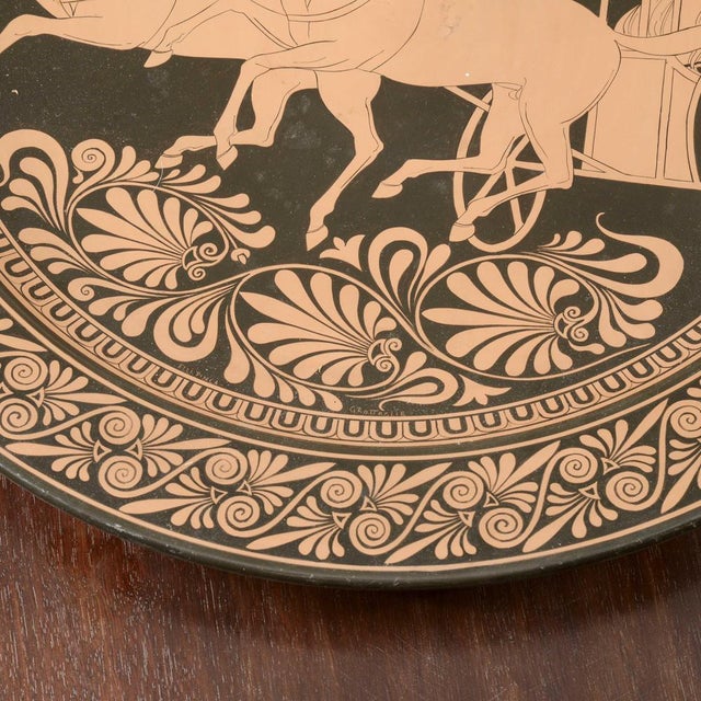 Ceramic wall plate with neoclassical scene decoration of a roman figure called a charioteer on top of a chariot pulled by...