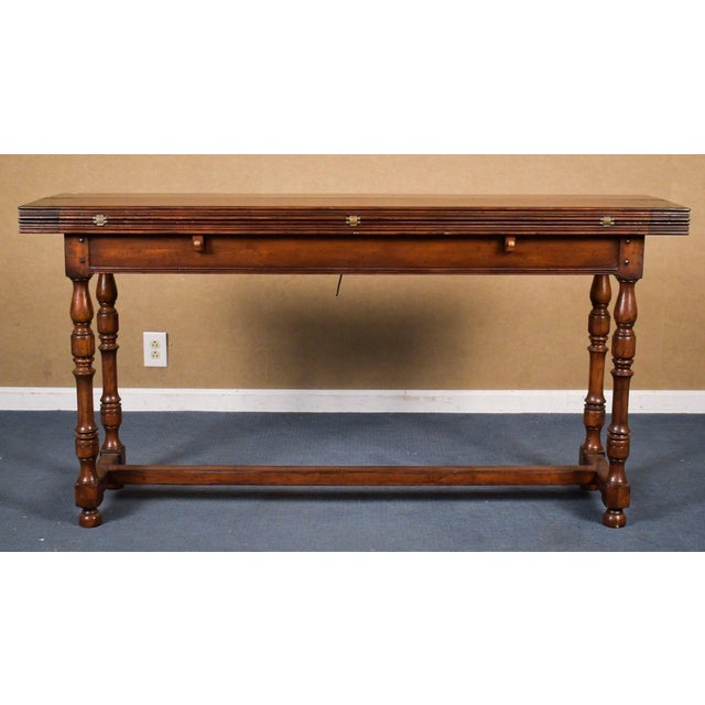 A Johnathan Charles planked top walnut console or sofa table with two fold-out style leaves with decorative butterfly...