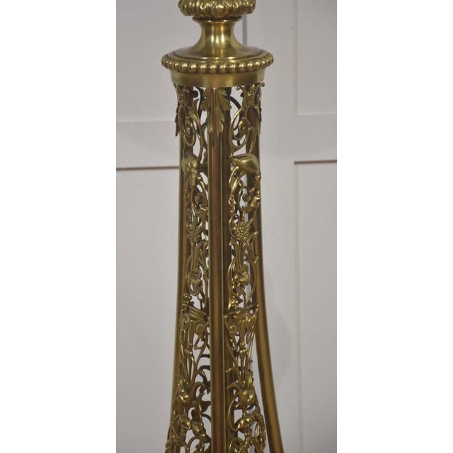 An impressive and finely worked brass floor lamp, distinguished by its richly pierced, tapering column and exceptional...