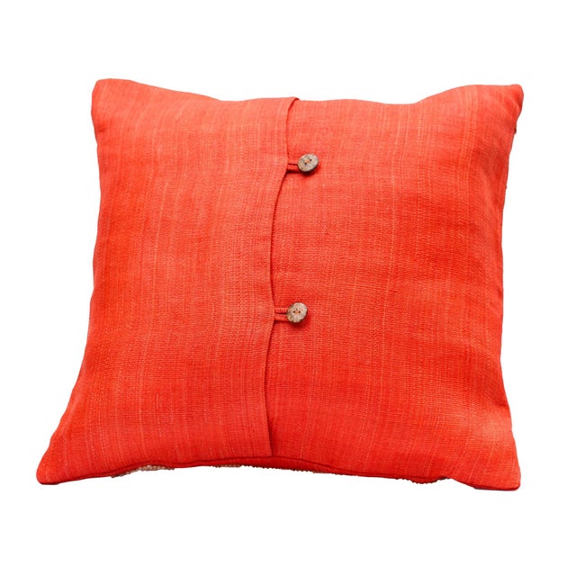 Vibrant handwoven abaca pillow cover in rich orange, accented with a coconut bead motif on the face and coconut shell...