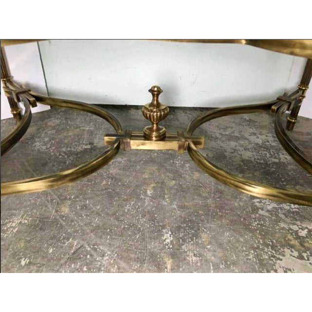 Elegant neoclassical style center table attributed to Maitland-Smith, featuring antiqued gilt metal, scroll supports,...