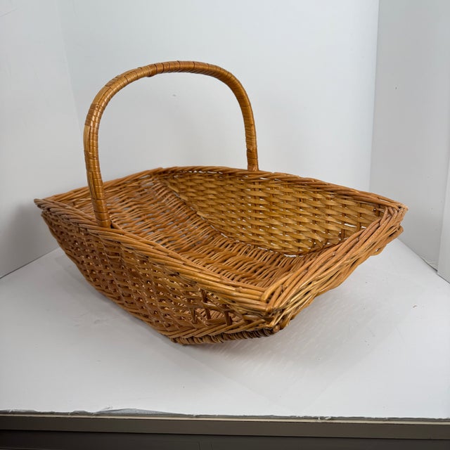 Purchased at Fortnum & Mason, London in 1980, a lovely woven wicker flared shape gathering basket . 21 1/2" Long X 12" w X...