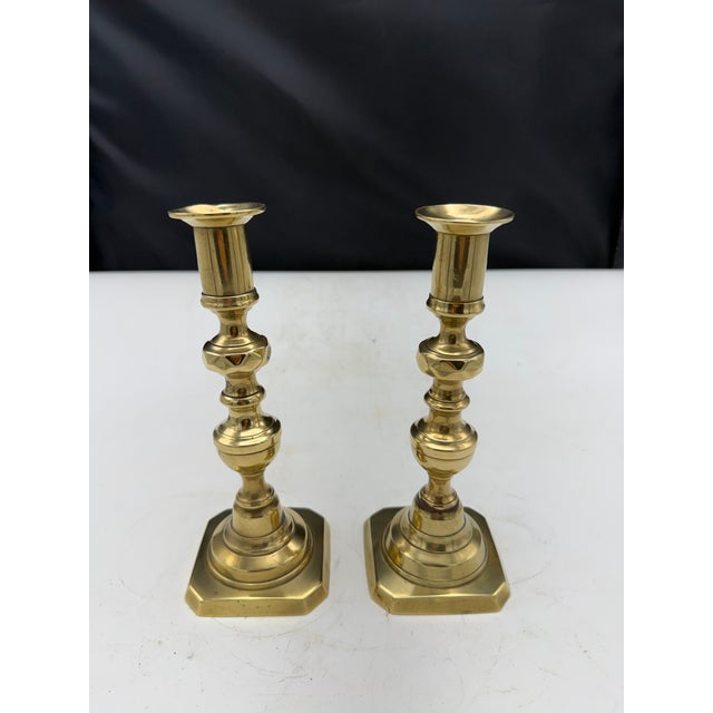 A lovely pair of vintage European Brass Candlesticks. The pare features a classic turned design and square bases. Some...