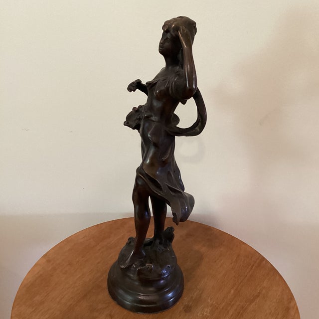 The product is an antique Italian bronze sculpture from the early 1900s, depicting a walking girl carrying a fruit basket....
