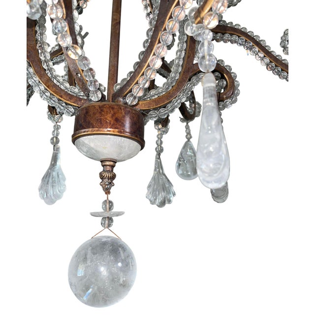 Elegant 20th century French chandelier featuring a scrolling wrought iron frame adorned with crystal beading, glass...
