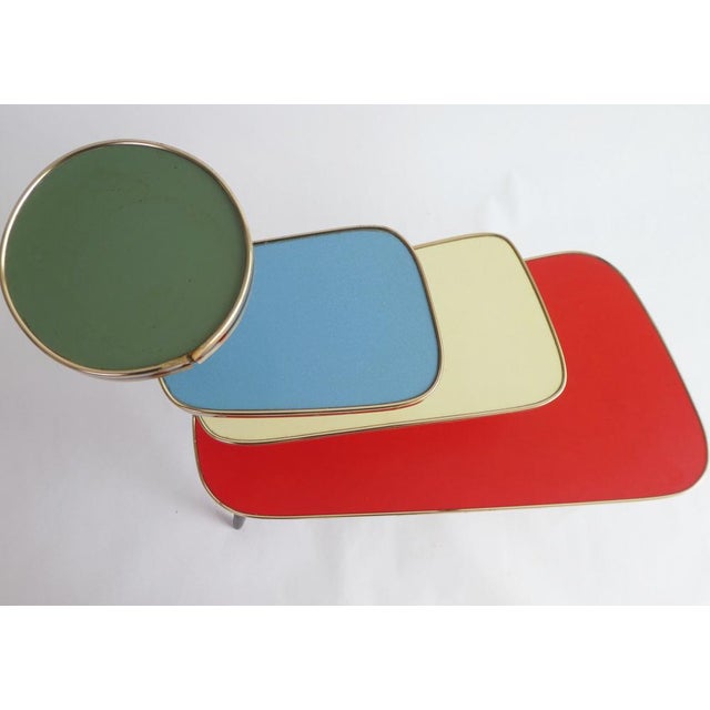 A large colourful plant stand from the 60's with 4 asymmetric tiers and a beautiful brass rim around them. It has 4 wooden...