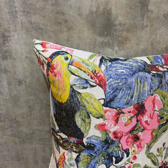 Four exotic bird species share a dense tropical field on a light cream ground: a toucan with a vivid orange-yellow beak at...