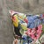 Four exotic bird species share a dense tropical field on a light cream ground: a toucan with a vivid orange-yellow beak at...