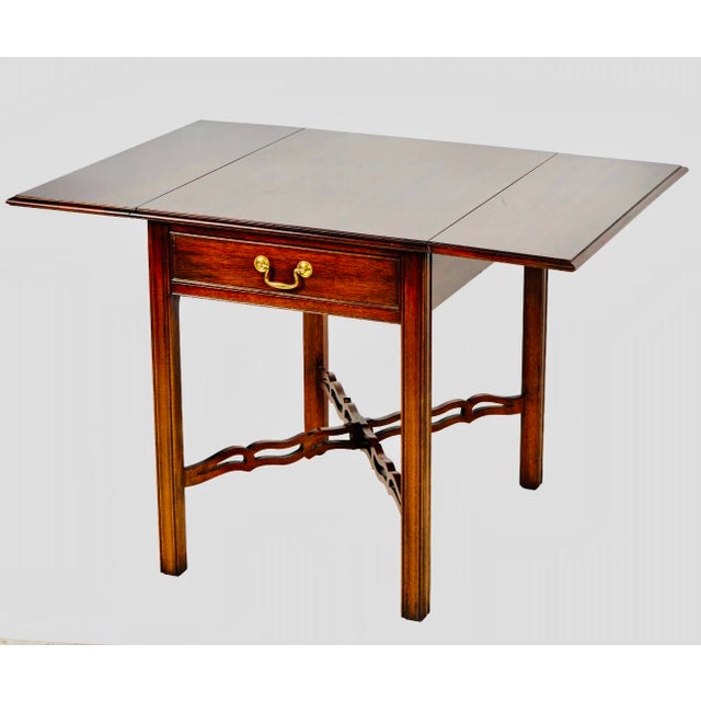 An elegant mahogany drop-leaf side table by Kindel Furniture of Grand Rapids, Michigan, crafted in the timeless Federal /...