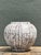 This vintage ceramic vase presents a refined, rounded silhouette accented by a striking vertical stripe pattern, a...