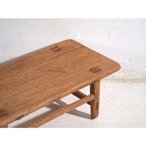 Chinese low table in solid elm wood, dating from around 1900, conceived as a functional piece within traditional domestic...