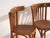 A set of two antique armchairs in bentwood, with a horseshoe back wrapping into the arms, over vertical splats and a...