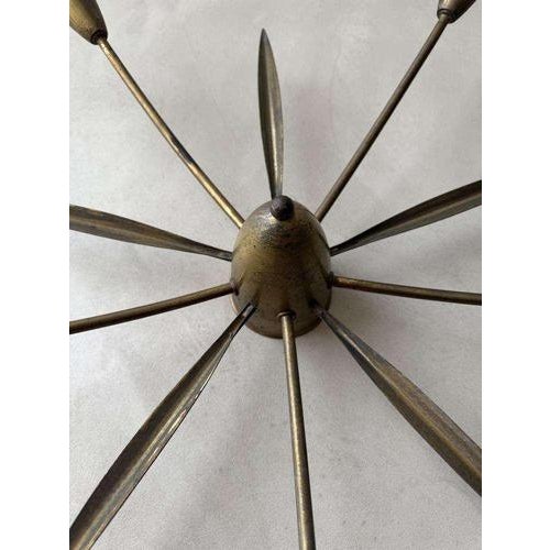 Mid-century Sputnik ceiling lamp from the 1950s, crafted in brass with a weathered, warm patina. The central shade forms...