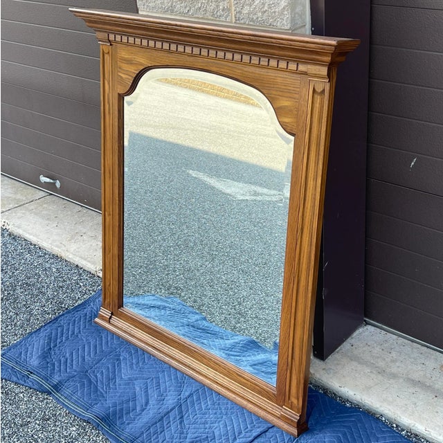 A vintage Pennsylvania House American Traditional solid oak wall mirror. American made. Circa late 20th century. Glass...